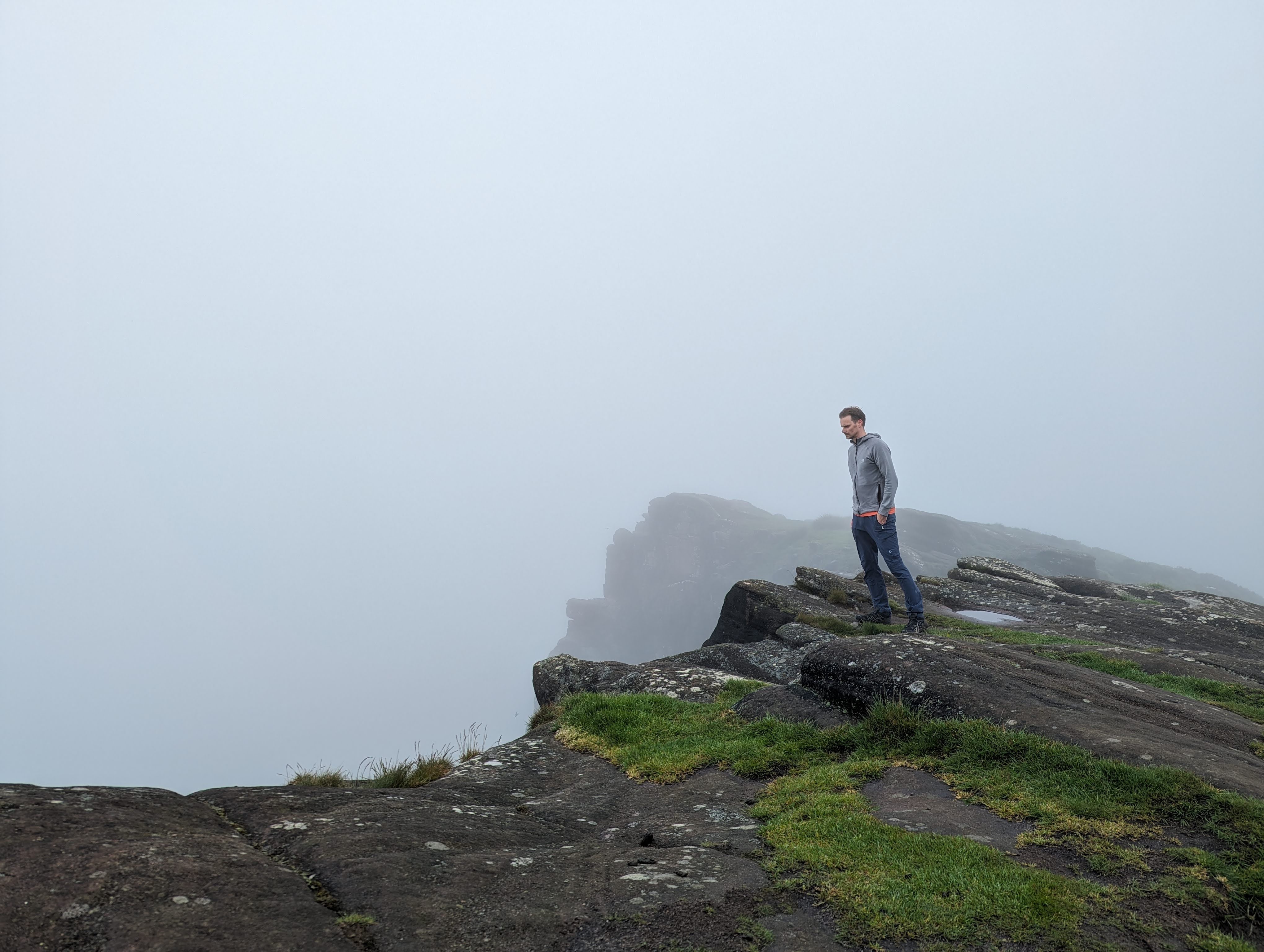 darren standing at the top of hen cloud looking over hte edge surrounded by fog