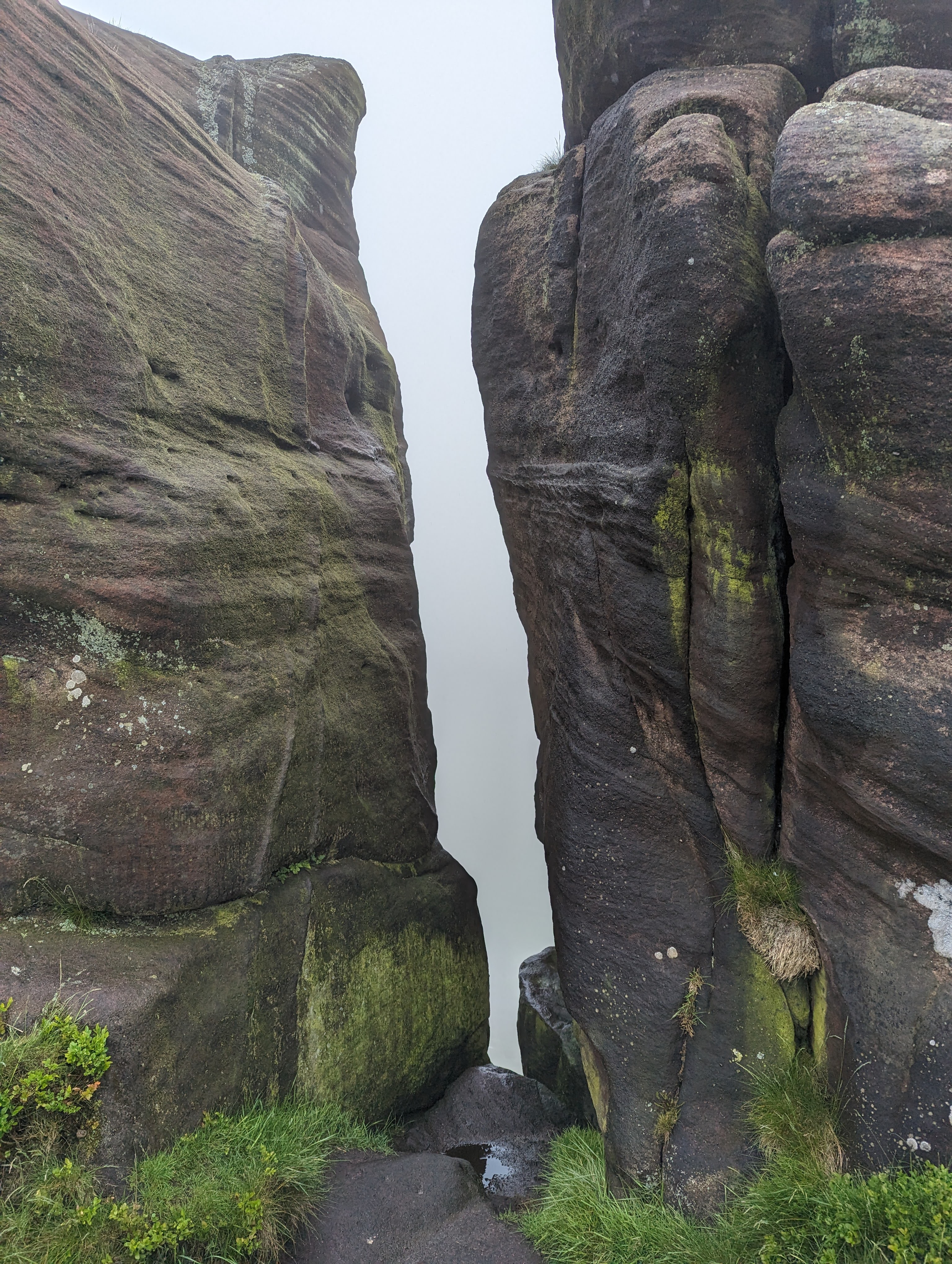 two rocks with a gap between, the view is obscured by fog